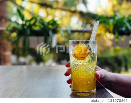 Refreshing summer drink with orange slice and mint in a crystal glass. Trendy healthy beverage inspiration for hot summer days. 131078865