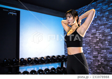 直立し髪を結んで準備する鍛えた女性 ジムで運動するかっこいい女性 筋トレ女子 直立し髪を結んで準備する鍛えた女性 ジムで運動するかっこいい女性 筋トレ女子 131078988