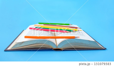 Bright color pencils on old books. 131079383