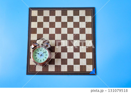 Alarm clock on chessboard ,strategy and time concept Alarm clock on chessboard ,strategy and time concept 131079518