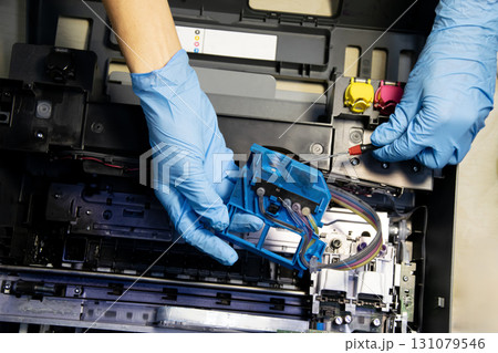 Top view of technician repairing and using printer repair tools. 131079546