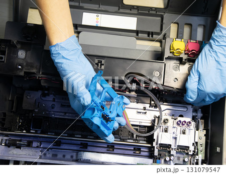 Top view of technician repairing and using printer repair tools. Top view of technician repairing and using printer repair tools. 131079547