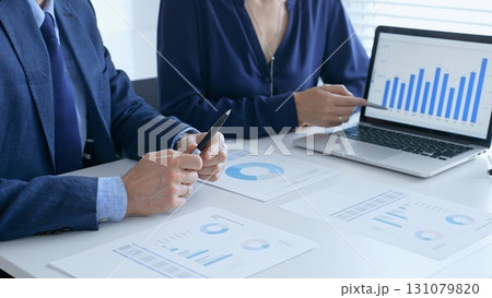 Businesspeople colleagues are reviewing financial data, analyzing charts and graphs, pointing at laptop screen during corporate meeting. Business people and finance concept Businesspeople colleagues are reviewing financial data, analyzing charts and graphs, pointing at laptop screen during corporate meeting. Business people and finance concept 131079820
