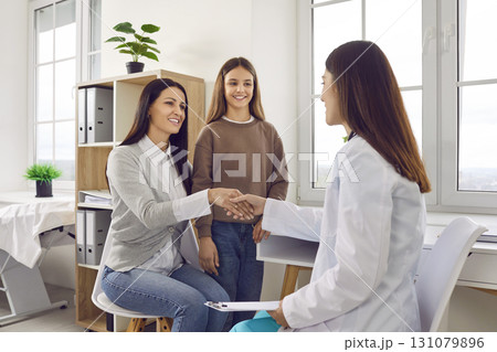 Happy mother and child visit their pediatrician or family doctor at the clinic or hospital Happy mother and child visit their pediatrician or family doctor at the clinic or hospital 131079896