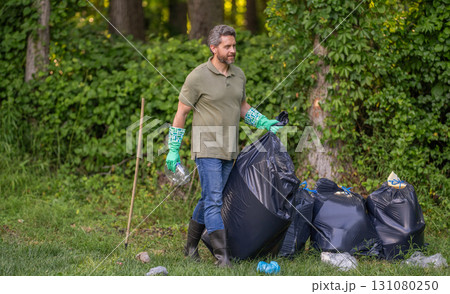 Environmental protection. Man environmental activist. Environmental conservation. Save environment. Environment plastic pollution. Volunteer man collecting garbage in forest. Copy space Environmental protection. Man environmental activist. Environmental conservation. Save environment. Environment plastic pollution. Volunteer man collecting garbage in forest. Copy space 131080250