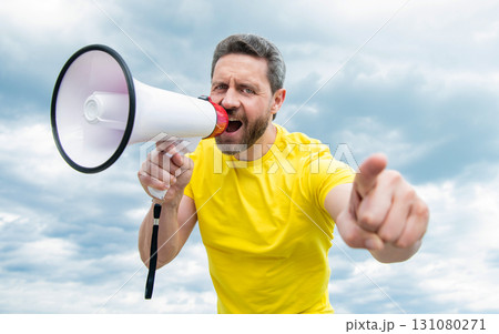 man in yellow shirt shout in loudspeaker on sky background. discount man in yellow shirt shout in loudspeaker on sky background. discount 131080271