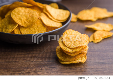 Crispy potato chips on wooden table. Crispy potato chips on wooden table. 131080283