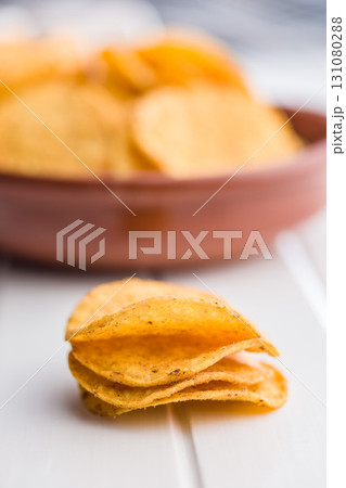 Crispy potato chips on white table. 131080288