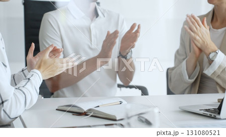 Business team applauding after achieving a goal during a productive meeting in a modern office environment, celebrating success and teamwork, close up 131080521