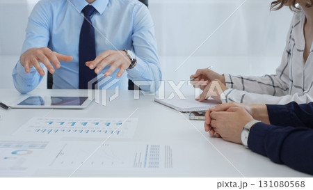 Business people reviewing financial metrics on digital screens, collaborating strategically while examining charts and graphs in office Business people reviewing financial metrics on digital screens, collaborating strategically while examining charts and graphs in office 131080568