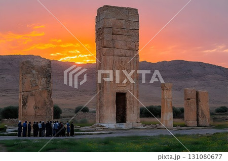 Ancient Stone Columns Silhouetted by Sunset, with Tourists Viewi 131080677