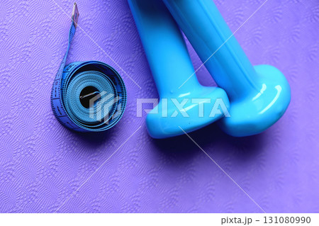 Barbells next to roll of tape measure. Shaping and fitness 131080990