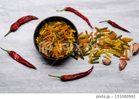 ingredients for cooking and italian pasta in black ceramic plate 131080992