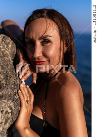 Woman, portrait, beach, young woman leaning on rock by sea with blue sky, serene and confident, copy space Woman, portrait, beach, young woman leaning on rock by sea with blue sky, serene and confident, copy space 131081112