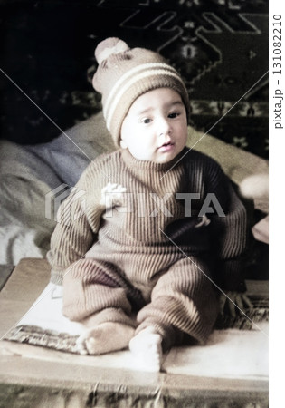 A vintage portrait of a cute little one-year-old boy in a suit and hat. Retro photo from the 1960s. 131082210