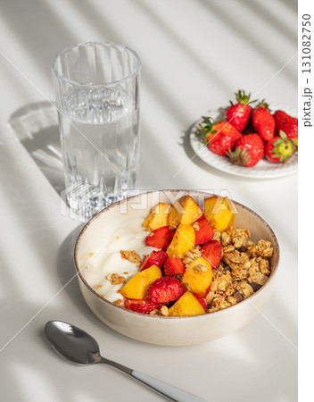 Granola or muesli with natural greek yogurt, strawberry and peach in a bowl on a white background Granola or muesli with natural greek yogurt, strawberry and peach in a bowl on a white background 131082750