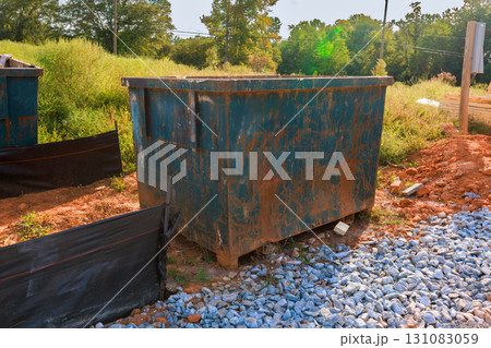 Rusty dumpster located in construction site, surrounded by rocks reflecting works day. Rusty dumpster located in construction site, surrounded by rocks reflecting works day. 131083059