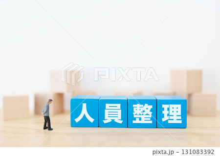 人員整理を示す青いブロックと落ち込むビジネスマン 人員整理を示す青いブロックと落ち込むビジネスマン 131083392