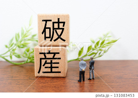 木製ブロックに破産の文字とミニチュアのビジネスマンのイメージ 木製ブロックに破産の文字とミニチュアのビジネスマンのイメージ 131083453