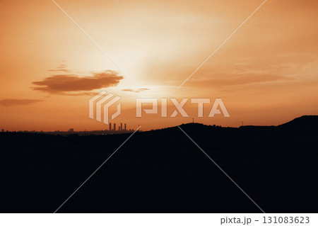 Beautiful sunset paints the sky with vibrant orange and casting warm glow over the landscape. A breathtaking sunrise skyline with orange hues and warm glow over the silhouetted land and horizon. Beautiful sunset paints the sky with vibrant orange and casting warm glow over the landscape. A breathtaking sunrise skyline with orange hues and warm glow over the silhouetted land and horizon. 131083623