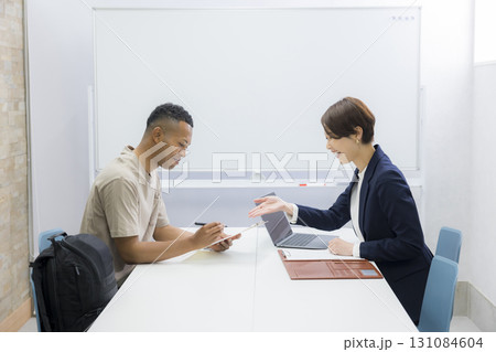 外国人の男性に説明をする女性 　 131084604