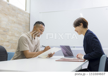 外国人の男性に説明をする女性 　 131084607