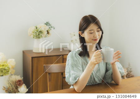 部屋でコーヒーを飲む若い 女性 部屋でコーヒーを飲む若い 女性 131084649