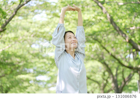 屋外で伸びをする40代女性 屋外で伸びをする40代女性 131086876