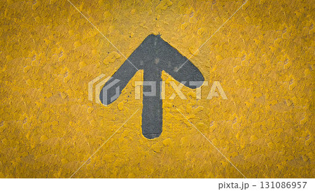 rustic Bold gray up arrow on a rough yellow wall conveys direction, guidance, and forward movement. The urban, street art feel highlights contrast, texture, and visual direction in a simple graphic 131086957