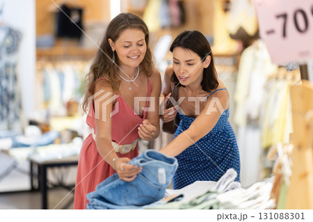 Two female friends choose jeans in the store 131088301
