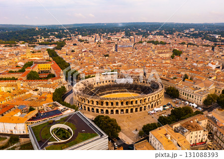 Aerial view of Roman amphitheatre on background with cityscape of Nimes 131088393