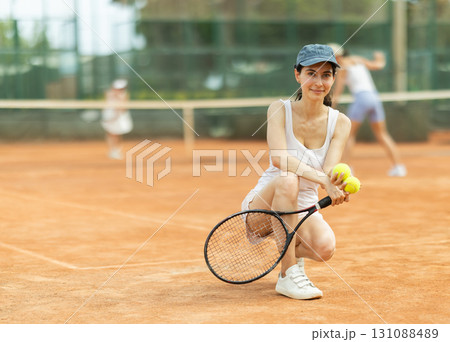 Portrait of sporty woman tennis player with racket and ball in hands 131088489