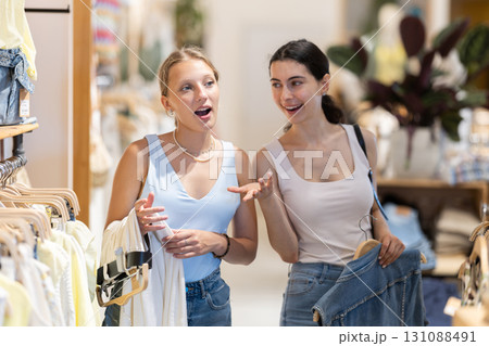 Two sisters girl chooses something in outlet clothing store Two sisters girl chooses something in outlet clothing store 131088491