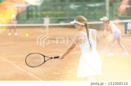 Female athlete plays tennis on open court Female athlete plays tennis on open court 131088518