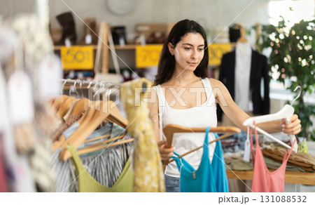 Woman on sale choosing dresses and tops in the store Woman on sale choosing dresses and tops in the store 131088532