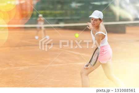 Woman playing tennis against female opponent on tennis court 131088561
