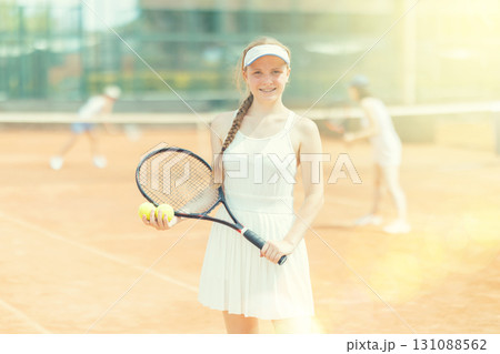 Portrait of sporty woman tennis player with racket and ball in hands 131088562