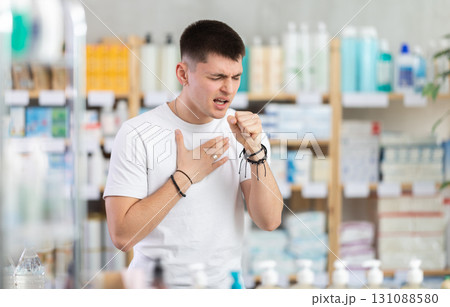 guy in a pharmacy with a cough and a sore throat 131088580