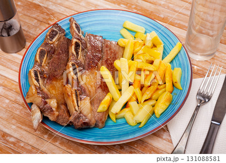 Churrasco veal ribs with side dish of french fries 131088581