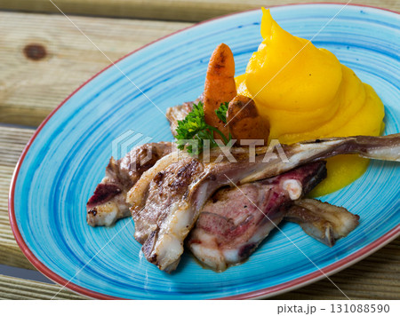 Grilled lamb with mashed jacket potato and mustard at plate with carrots Grilled lamb with mashed jacket potato and mustard at plate with carrots 131088590