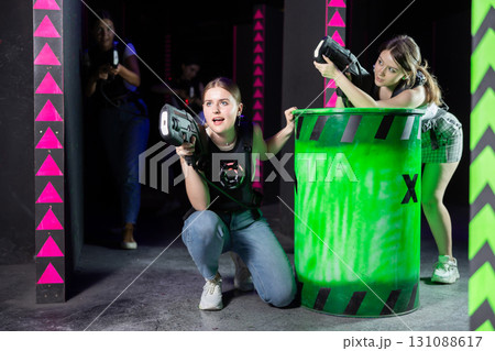 Girls play laser tag, jokingly fight with light weapons 131088617