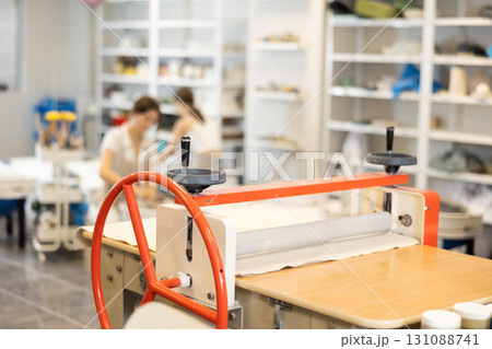 Machine clay press roller is ready for operation in pottery workshop, employees working day 131088741