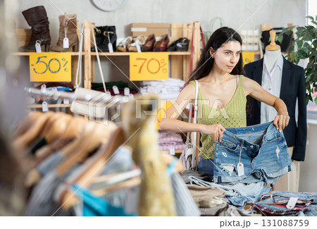 Woman with black hair choosing pants in a store 131088759