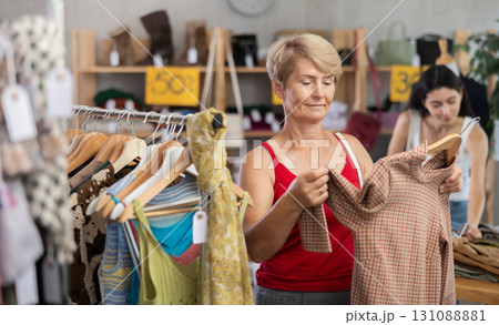 Mature woman choosing a brown sweater 131088881