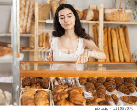 Young woman choosing pastries in bakery Young woman choosing pastries in bakery 131089076