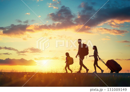 Happy family walking with luggage during sunset on vacation Happy family walking with luggage during sunset on vacation 131089149