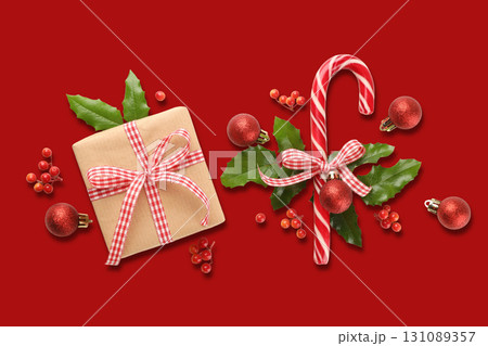 A gift box with a bow and a candy cane among Christmas ornaments 131089357