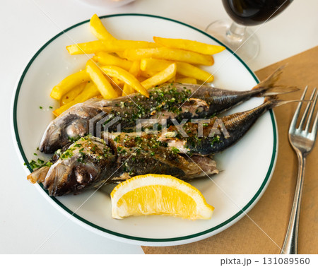 Grilled scomber with fried potatoes and lemon slice 131089560