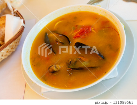 Delicious seafood soup with mussels and prawns served Delicious seafood soup with mussels and prawns served 131089563