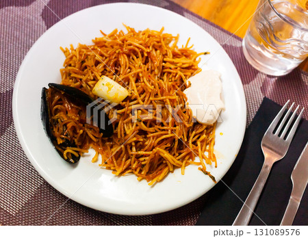 Spanish seafood fideua, noodle paella with aioli Spanish seafood fideua, noodle paella with aioli 131089576
